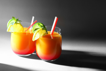 Tequila Sunrise cocktail in glasses on dark background