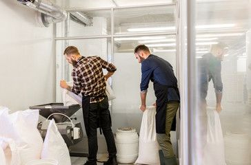 men with malt bags and mill at craft beer brewery