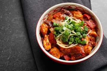 Bowl with delicious chili turkey on table