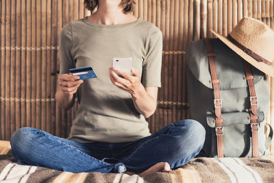 Young Woman On Vacations Using Smartphone And Credit Card. Online Shopping And Travel Concept