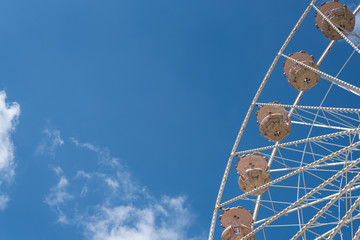ferris wheel on funfair against blue summer sky