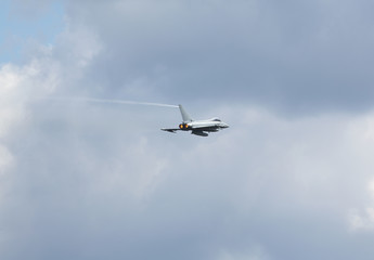Fototapeta na wymiar Modern jet fighter going full speed. Afterburner glowing orange.