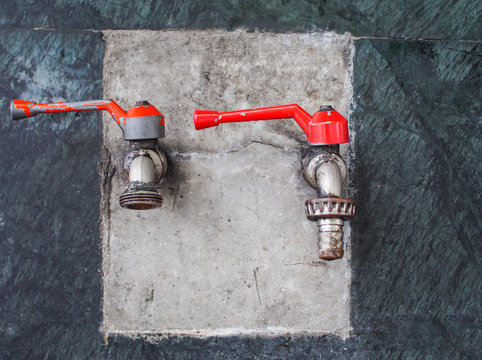 Old faucets are mounted on the wall. Selective focus