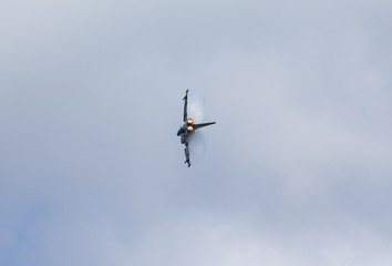 Cloud condensating on a jet fighter with afterburner on.