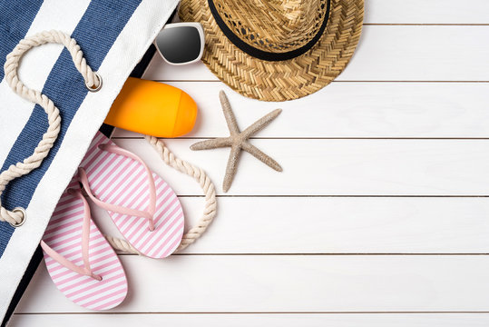 Beach accessories on white wooden table. Summer background