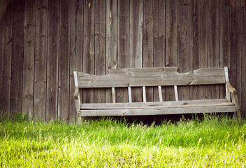 Bench near the house in the village. Gray old wood