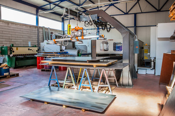 Industrial building inside. Metal plate cutting machine.