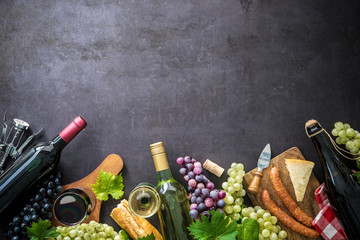 Obraz na płótnie Canvas Wine bottles with grapes, cheese, ham and corks