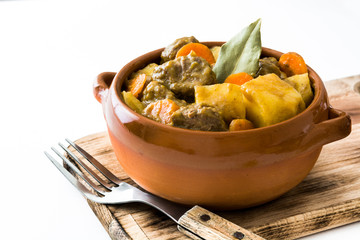 Beef meat stewed with potatoes, carrots and spices in ceramic bowl isolated on white background
