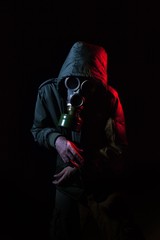 Hombre con mascara de gas y un abrigo militar en un fondo oscuro