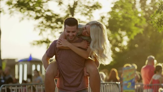 Medium slow motion shot of man carrying woman piggyback. Pleasant Grove, Utah, United States