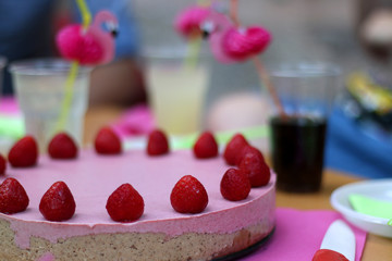 Birthday party with vegan raw strawberry cake and cute flamingo straws. Ingredients for the cake are: strawberries, coconut butter, coconut flour, cashew, dates, minced walnuts and stevia.
