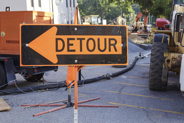 detour sign diverting cars around a construction site