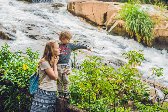 Mother and son on the background of Beautiful Camly waterfall In Da Lat city
