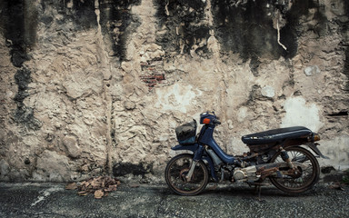Old motorcyle with Old wall texture background  in Bangkok, Thailand