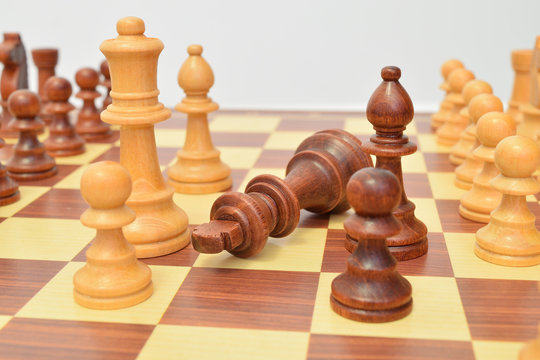 King at the foot of various pieces on the chessboard