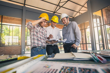 Engineer and Architect working at Construction Site. Engineer builders in safety vest with blueprint at construction site.