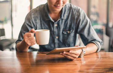 Man with a tablet computer. Asian business man using digital tablet computer in coffee shop.