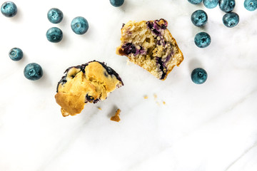 Two halves of blueberry muffin with fresh berries and copyspace