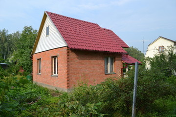 Brick house with a red roof. Russia