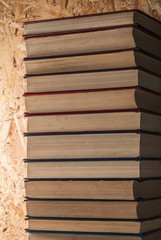 a stack of books on wooden background, closeup