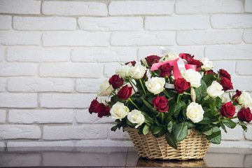 Fototapeta na wymiar Bouquet of roses in a wooden basket 
