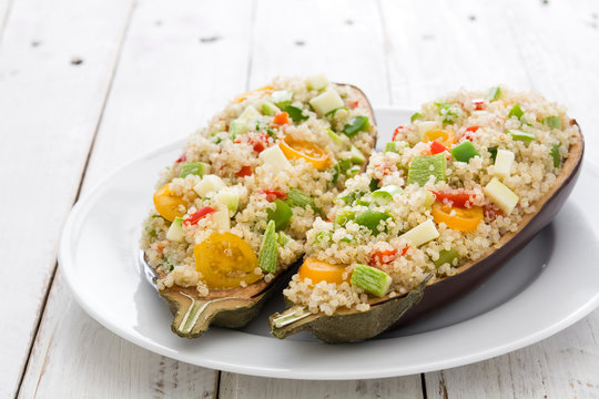 stuffed eggplant with quinoa and vegetables on white wooden table