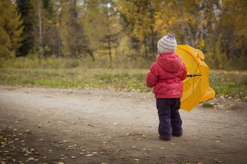 Fototapeta premium little girl with umbrella in autumn Park back