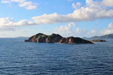 Fototapeta na wymiar Small island off the coast of St. Thomas with clouds in the sky