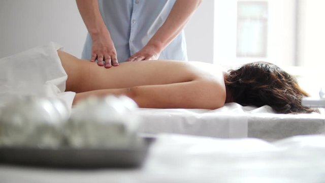 Physiotherapist massaging woman's back in the medical office