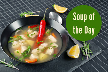 Plate with chicken soup and chili pepper on table