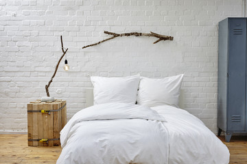 vintage loft white brick wall bed and birch branches