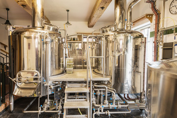 Modern beer plant (brewery), with brewing kettles, vessels, tubs and pipes made of stainless steel.