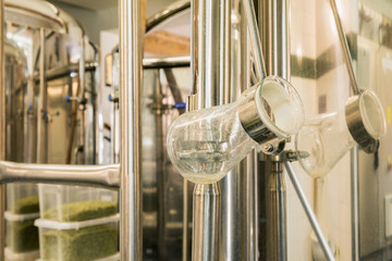 Modern beer plant (brewery), with brewing kettles, vessels, tubs and pipes made of stainless steel.
