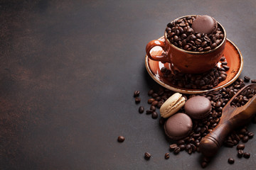 Coffee cup with roasted beans and macaroons