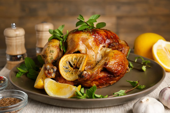 Homemade baked chicken with lemon and mint on table
