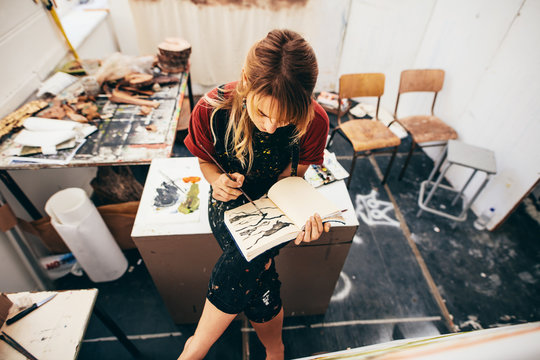 Female artist drawing pictures in her workshop