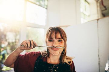Female painter looking funny with paint brush