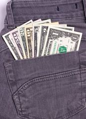 Dollars bills in black jeans back pocket.