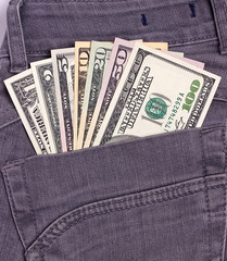 Dollars bills in black jeans back pocket.