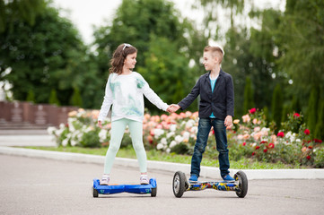 little boy and girl ride on mini segway, self-balancing scooter board or hover board scooter in green park .Eco city 