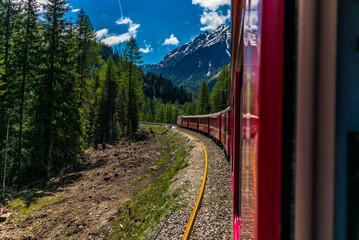 Red train slowly climbing to the Bernina Pass in the Swiss Alps - 3