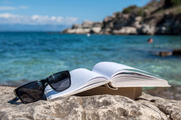 Fototapeta na wymiar Reading open book at beach near the sea during summer vacation