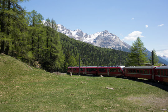 Red train slowly climbing to the Bernina Pass in the Swiss Alps - 5