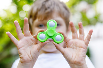 School kid playing with Tri Fidget Hand Spinner outdoors