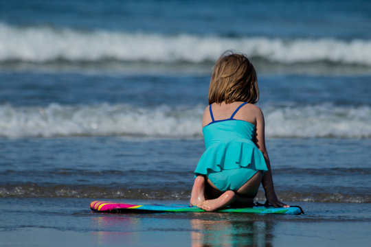 A child in blue bathing suit playing in the waves of the sea (Series 1)