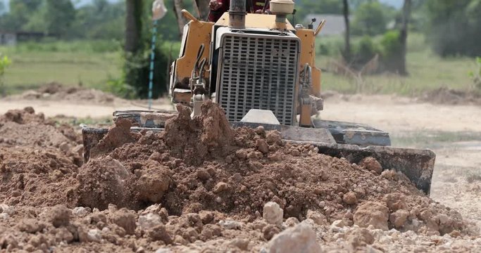 Unidentified worker control Bulldozer to excavator grader removing the ground