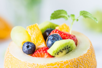 Fruit salad in melon on wooden table