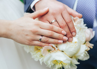 Obraz na płótnie Canvas the groom holds the bride holding hands on a wedding bouquet