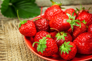 Strawberries in bowl on rustic table.